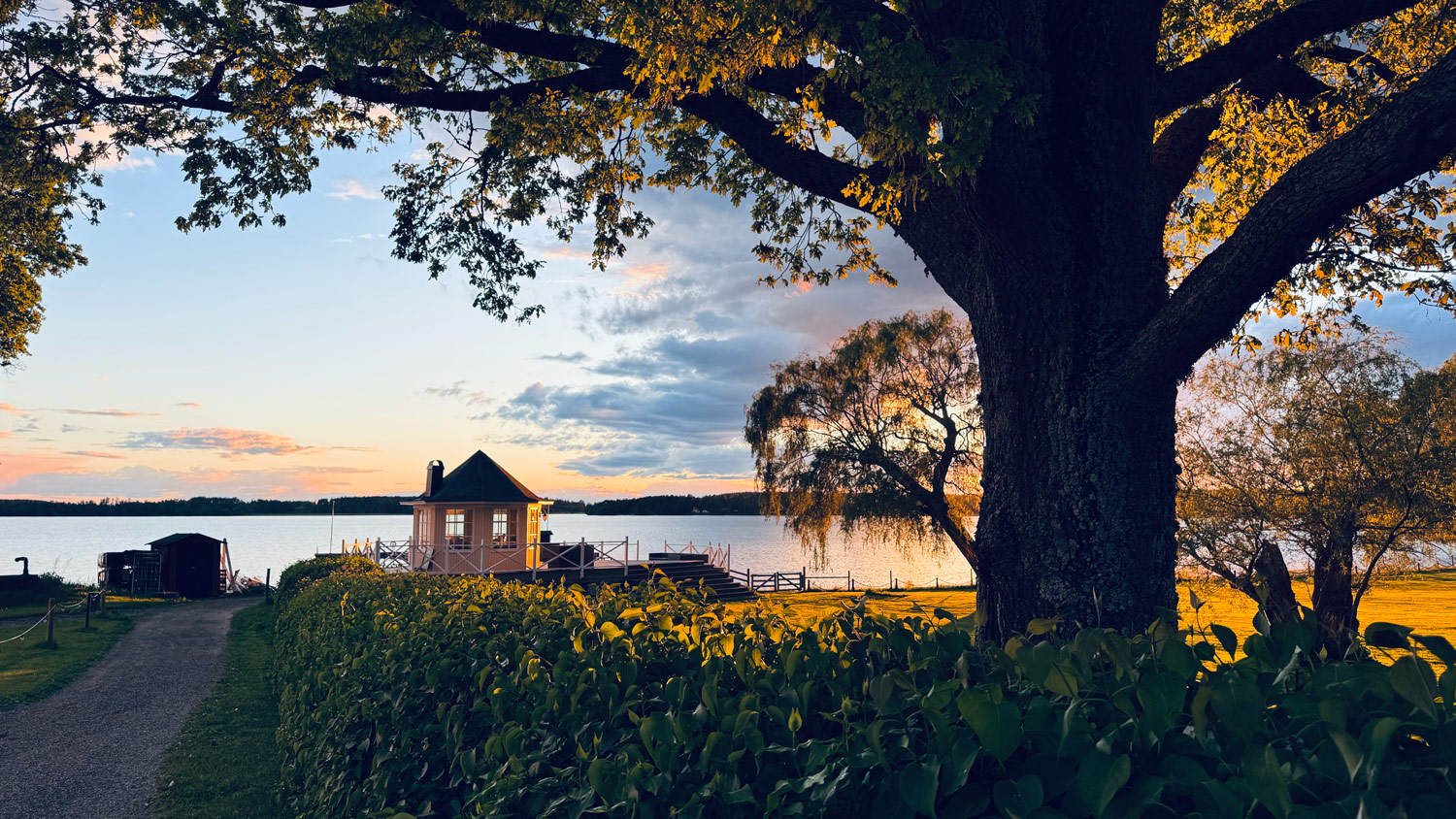 Kvällsljus över Kräggas lusthus och sjöspa.